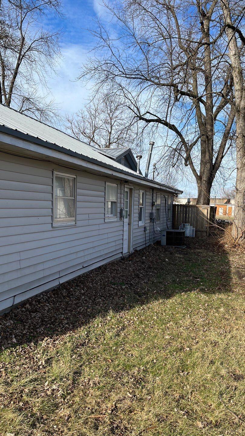 back of house with a lawn and central AC