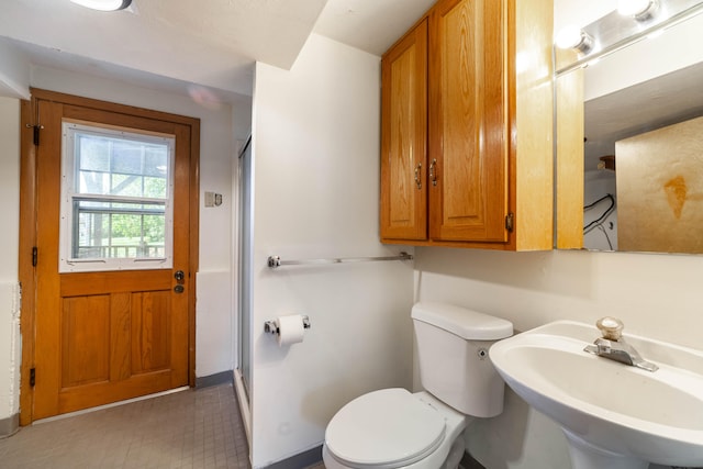 bathroom featuring an enclosed shower, toilet, and sink