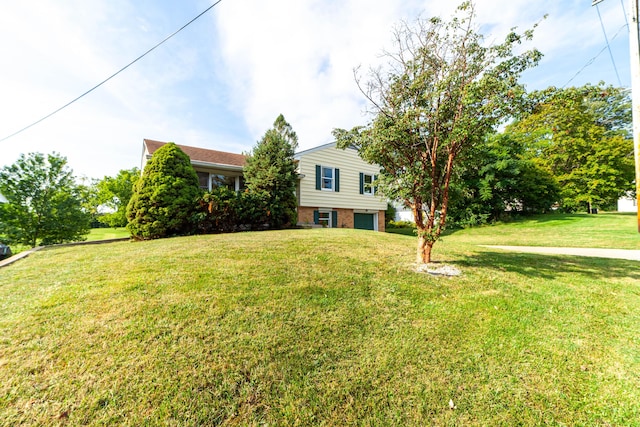 view of front of home featuring a garage, a front yard, and brick siding