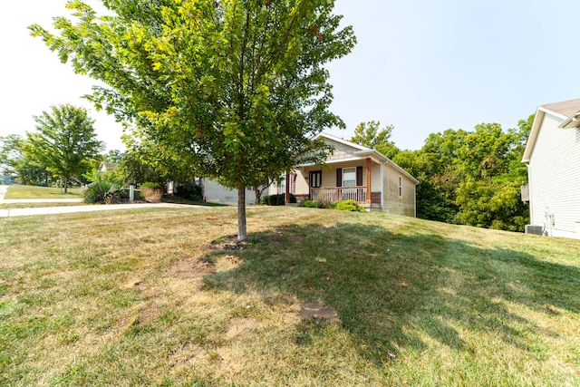 view of front of home featuring central AC, covered porch, and a front lawn