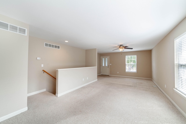 unfurnished room featuring light colored carpet and ceiling fan