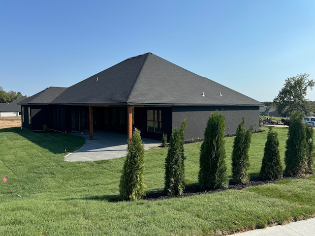 back of house featuring a carport and a lawn