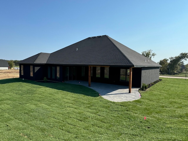 rear view of house featuring a patio and a lawn