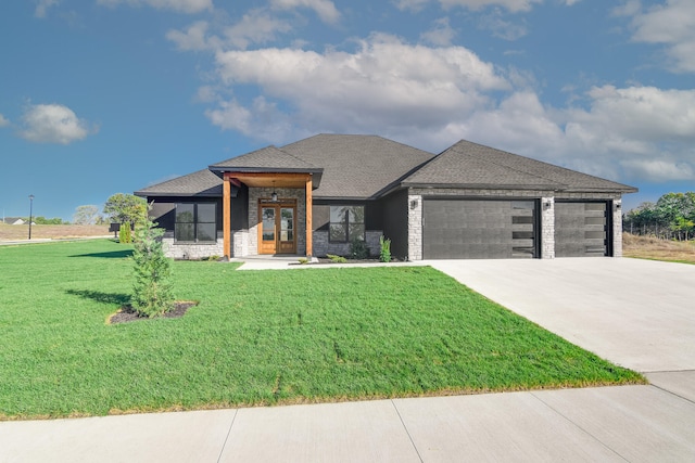 prairie-style home featuring a garage and a front lawn