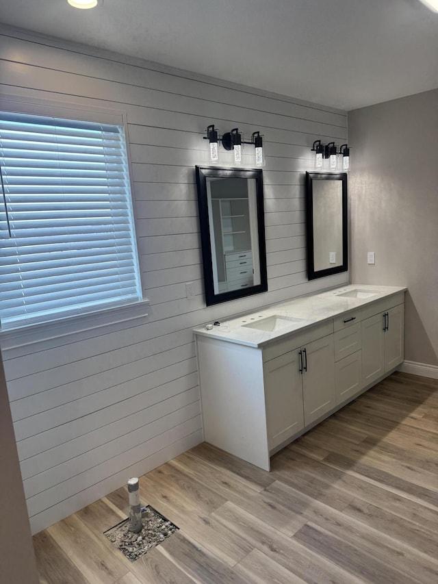 bathroom featuring hardwood / wood-style flooring, a healthy amount of sunlight, vanity, and wood walls