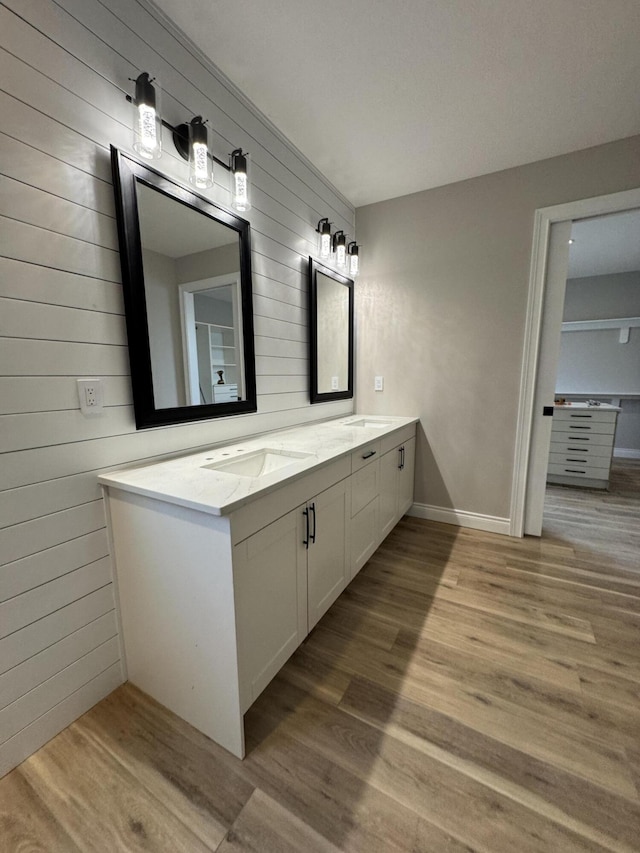 bathroom featuring wood-type flooring, vanity, and wood walls