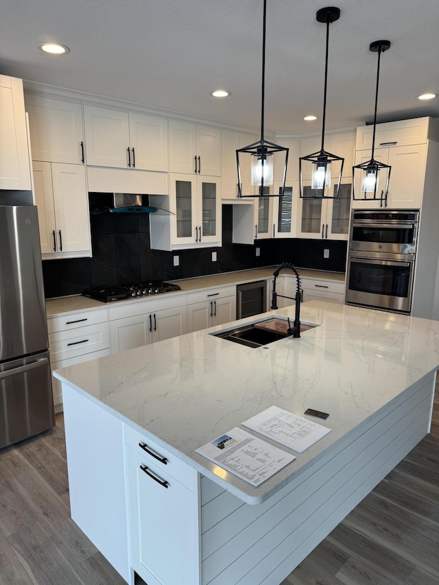 kitchen with white cabinetry, decorative light fixtures, and stainless steel appliances