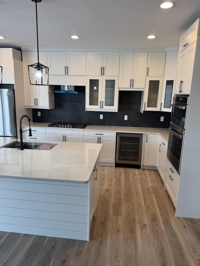 kitchen featuring stainless steel refrigerator, white cabinetry, decorative light fixtures, and wine cooler