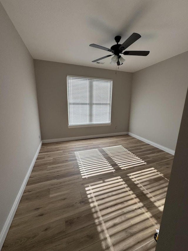 spare room featuring dark wood-type flooring and ceiling fan