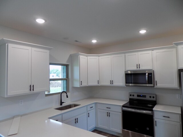 14 Carnival Ln, Centralia, MO 65240 - kitchen with stainless steel appliances, light countertops, white cabinets, and recessed lighting