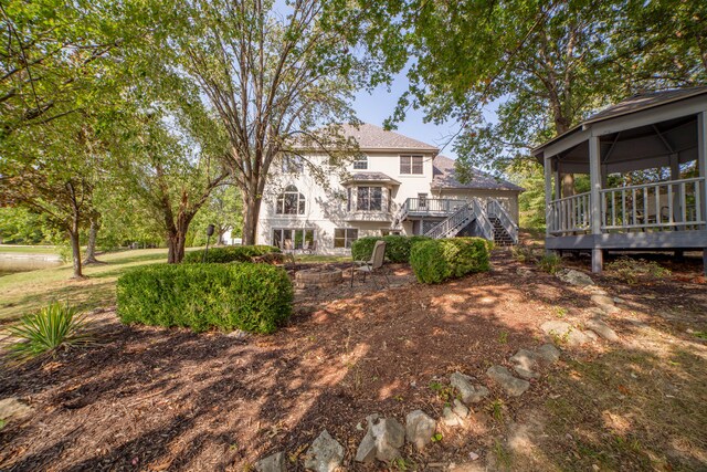 rear view of house with a sunroom and a deck