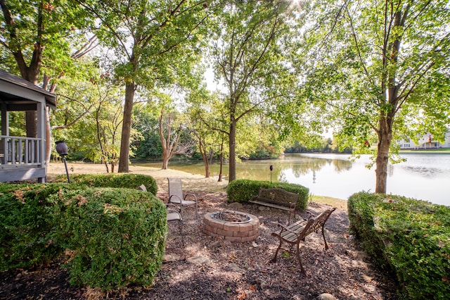 view of yard with an outdoor fire pit and a water view