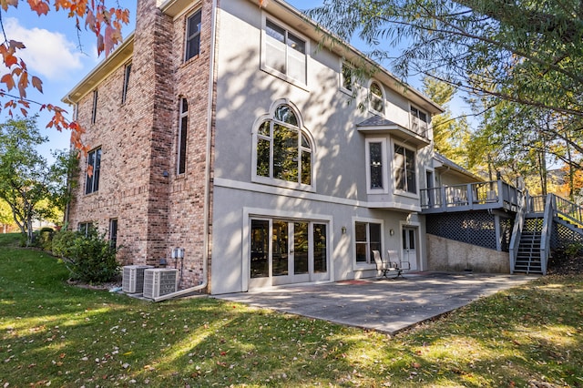 back of property with a patio, a deck, a lawn, and cooling unit