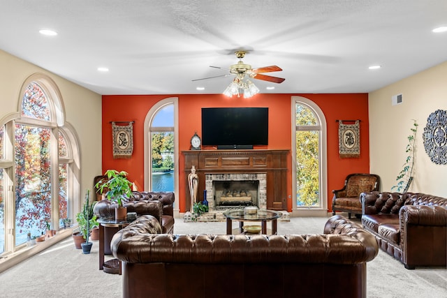 carpeted living room with ceiling fan and a textured ceiling