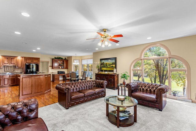 living room with light hardwood / wood-style floors and ceiling fan