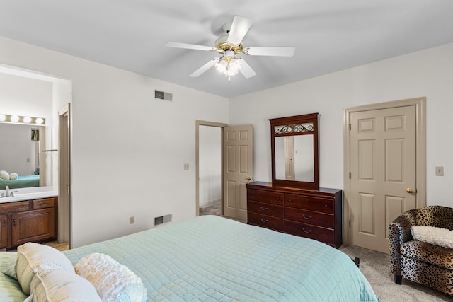 carpeted bedroom with connected bathroom, sink, and ceiling fan