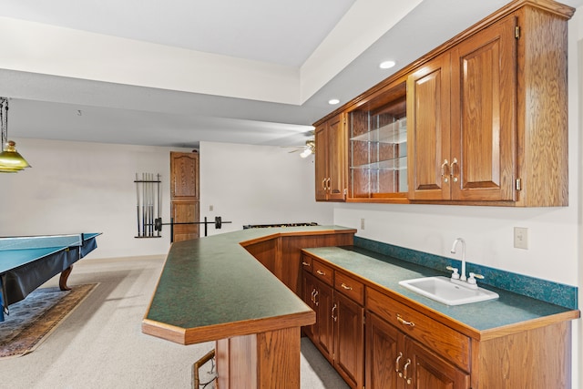 kitchen featuring a kitchen island, sink, a kitchen breakfast bar, and light carpet