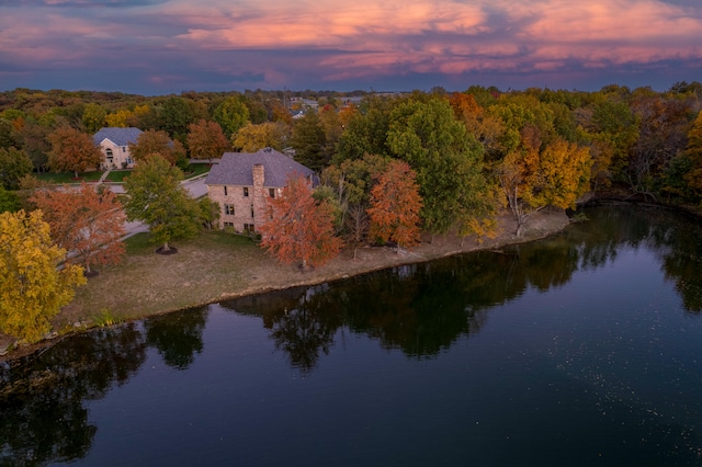 aerial view at dusk featuring a water view