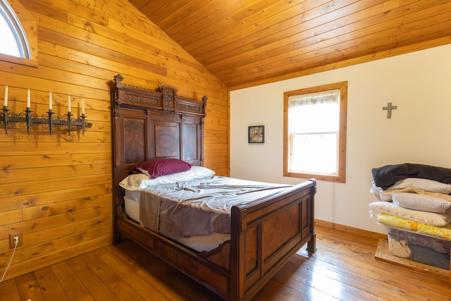 bedroom featuring multiple windows, hardwood / wood-style floors, and vaulted ceiling