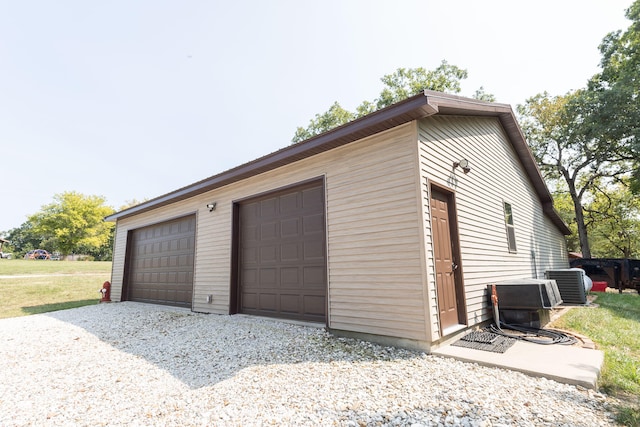 garage with central AC unit and a yard