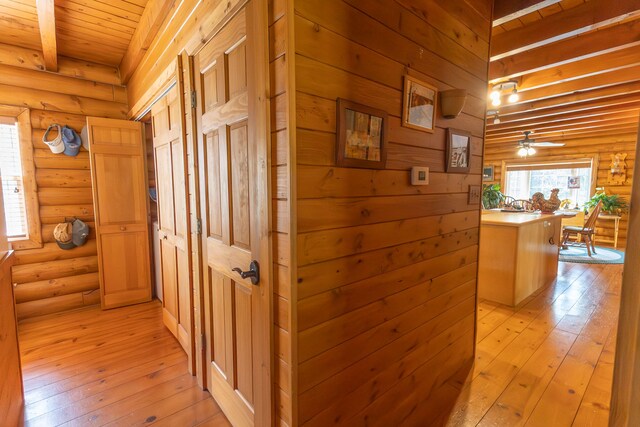 corridor featuring light hardwood / wood-style flooring, beamed ceiling, and wooden ceiling