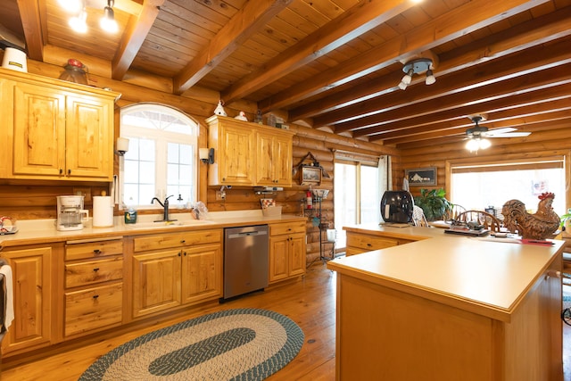 kitchen with light hardwood / wood-style floors, stainless steel dishwasher, sink, and beam ceiling