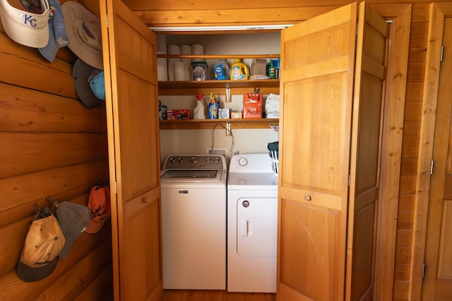 clothes washing area with light wood-type flooring and washing machine and clothes dryer