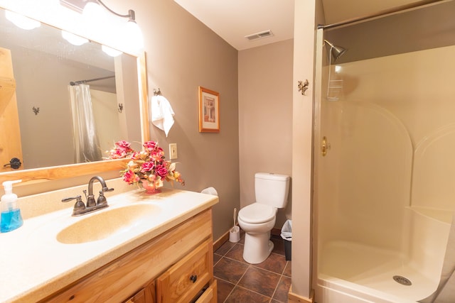 bathroom with vanity, toilet, walk in shower, and tile patterned floors