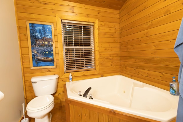 bathroom with a tub to relax in, toilet, and wooden walls