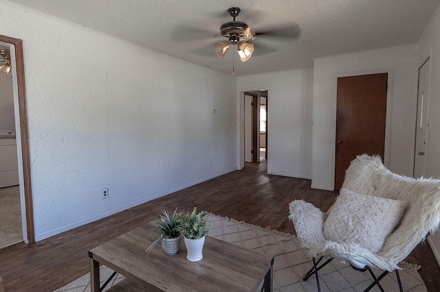 living room featuring ceiling fan, dark hardwood / wood-style floors, and a textured ceiling