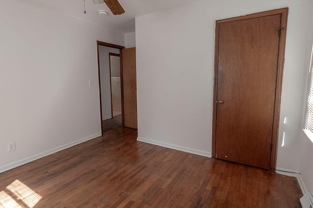 unfurnished bedroom featuring ceiling fan and dark hardwood / wood-style floors