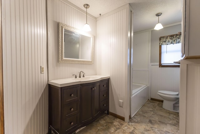 bathroom with wood walls, vanity, a textured ceiling, and toilet