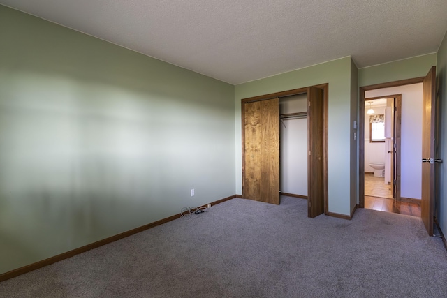 unfurnished bedroom with carpet, a textured ceiling, and a closet