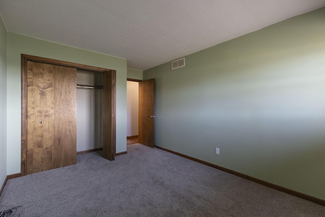 unfurnished bedroom featuring a closet, carpet, and a textured ceiling