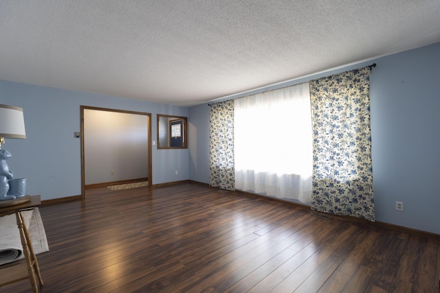 unfurnished room with dark hardwood / wood-style floors and a textured ceiling