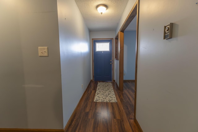 doorway featuring a textured ceiling and dark wood-type flooring