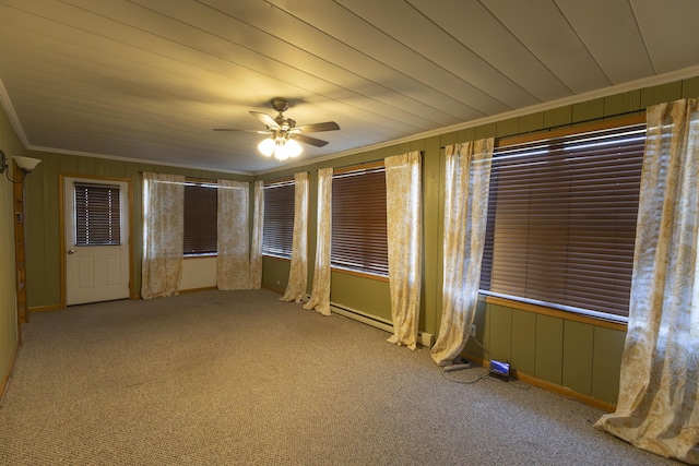 carpeted spare room featuring ceiling fan, crown molding, and wooden walls