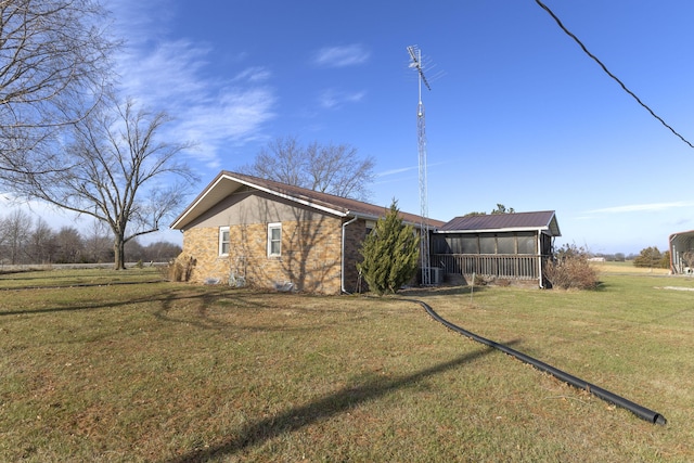 view of home's exterior featuring central air condition unit, a lawn, and a sunroom