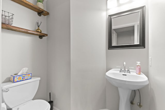 half bathroom with toilet and baseboards