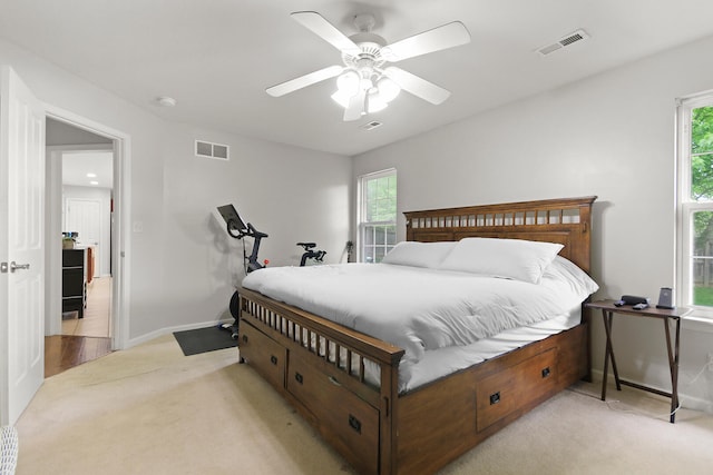 bedroom featuring ceiling fan, light carpet, and visible vents