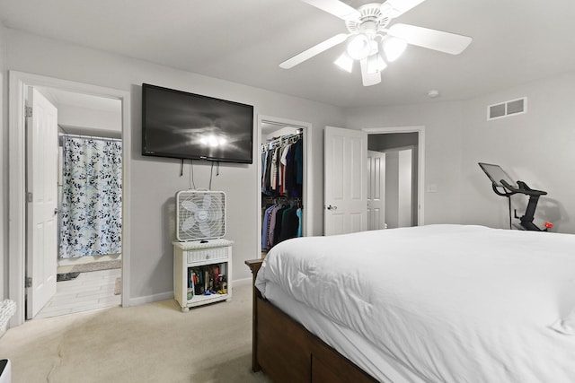 bedroom with a closet, visible vents, light carpet, a spacious closet, and connected bathroom