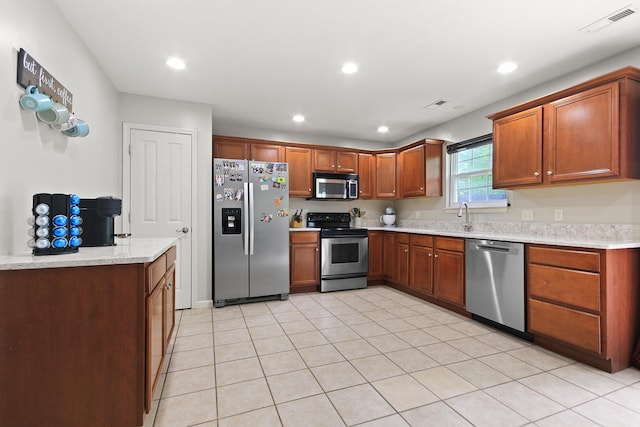 kitchen featuring recessed lighting, brown cabinetry, visible vents, a sink, and stainless steel appliances