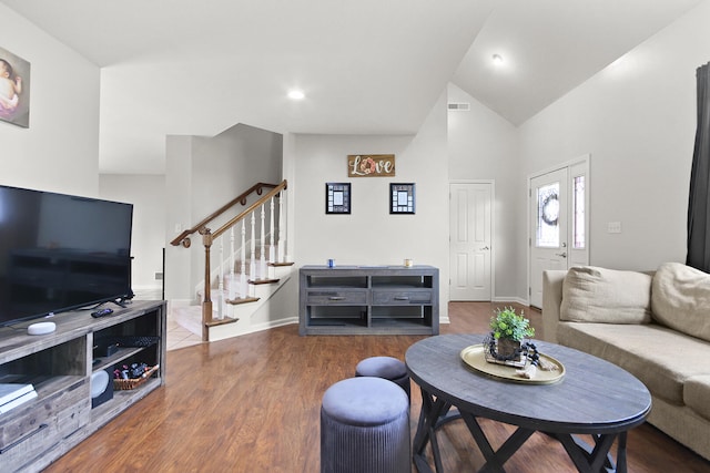 living area featuring wood finished floors, high vaulted ceiling, stairway, baseboards, and visible vents