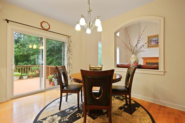 dining area featuring wood-type flooring and a notable chandelier