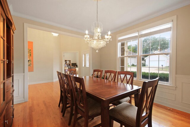 dining area featuring ornamental molding, light wood-type flooring, and a healthy amount of sunlight