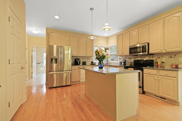 kitchen with tasteful backsplash, stainless steel appliances, light wood-type flooring, pendant lighting, and a center island