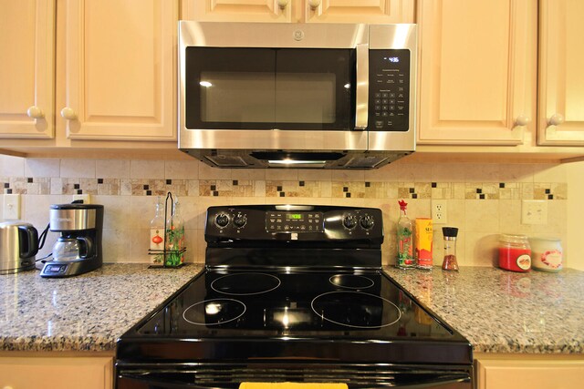 kitchen with backsplash, black / electric stove, and light stone counters