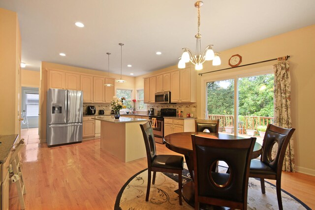 dining room featuring light wood-type flooring and a notable chandelier