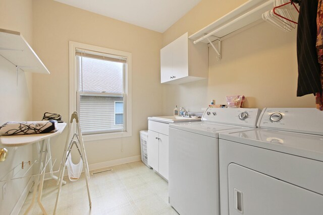 washroom featuring cabinets, separate washer and dryer, and sink