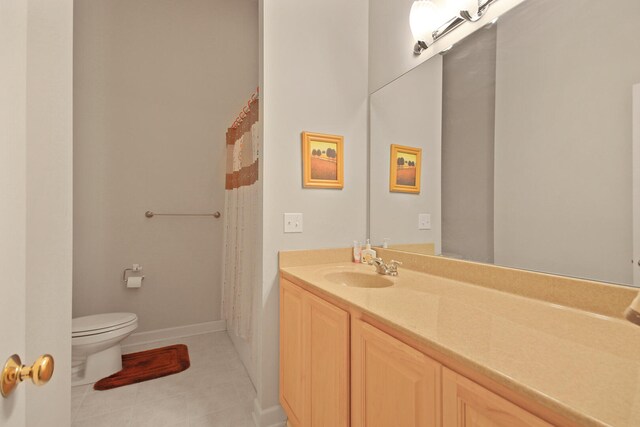 bathroom featuring vanity, tile patterned flooring, and toilet